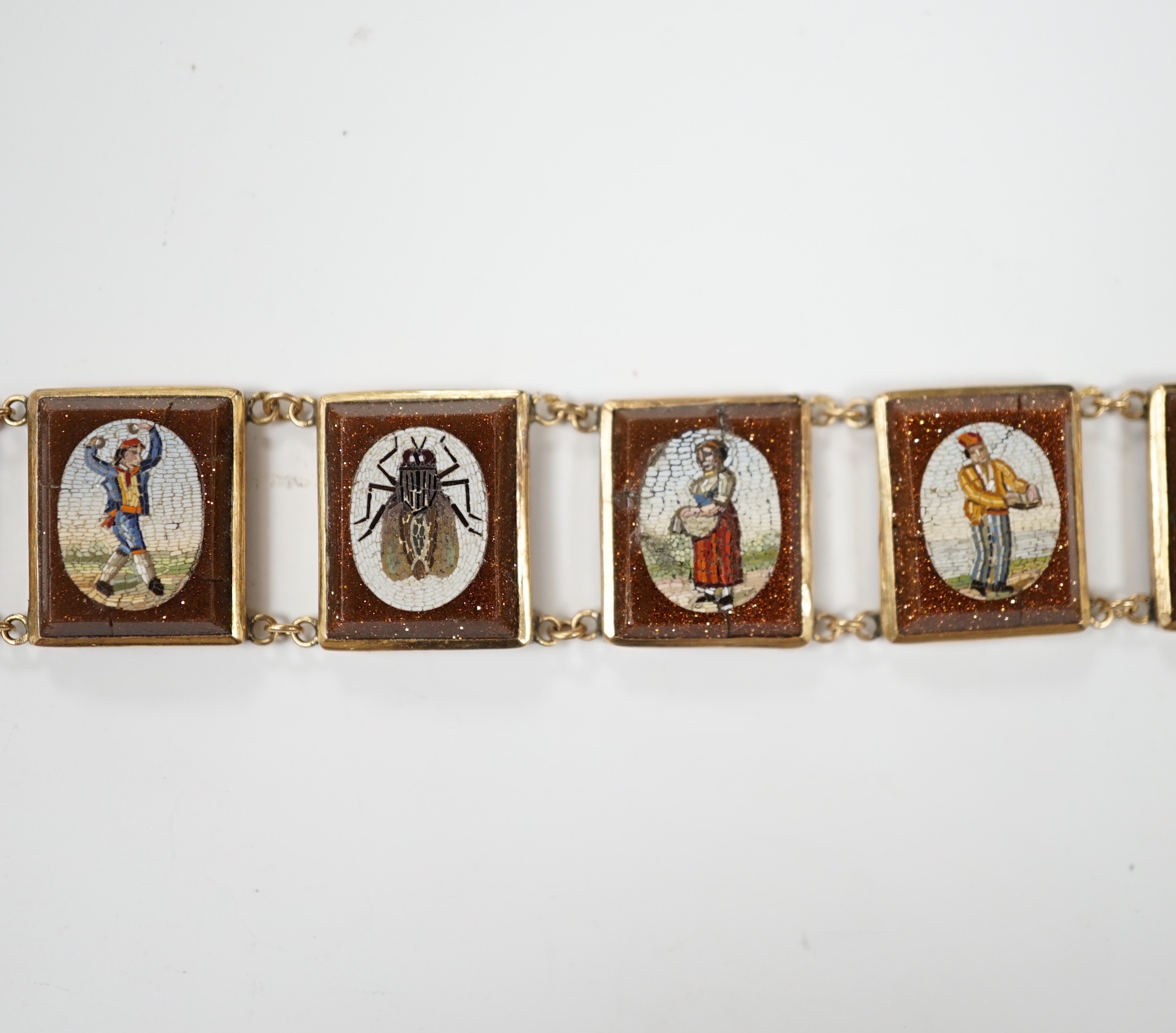 An Italian yellow metal, micro mosaic and goldstone set bracelet, with panels of Italian figures and insects, 17.3cm, gross weight 15.6 grams